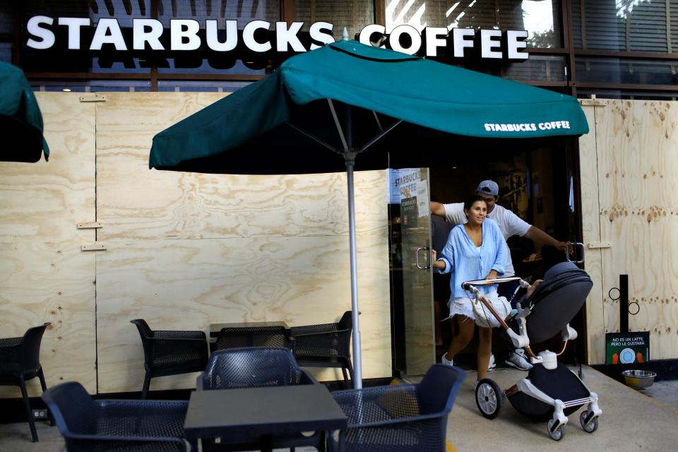 People exit from a boarded up Starbucks Coffee store ahead of the arrival of Hurricane Beryl, in Playa del Carmen, Mexico July 3, 2024 (REUTERS)