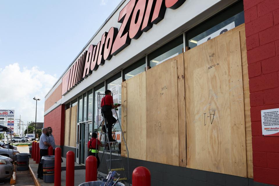 Workers board up a business to avoid damage ahead of Hurricane Beryl, in Merida, Mexico (REUTERS)